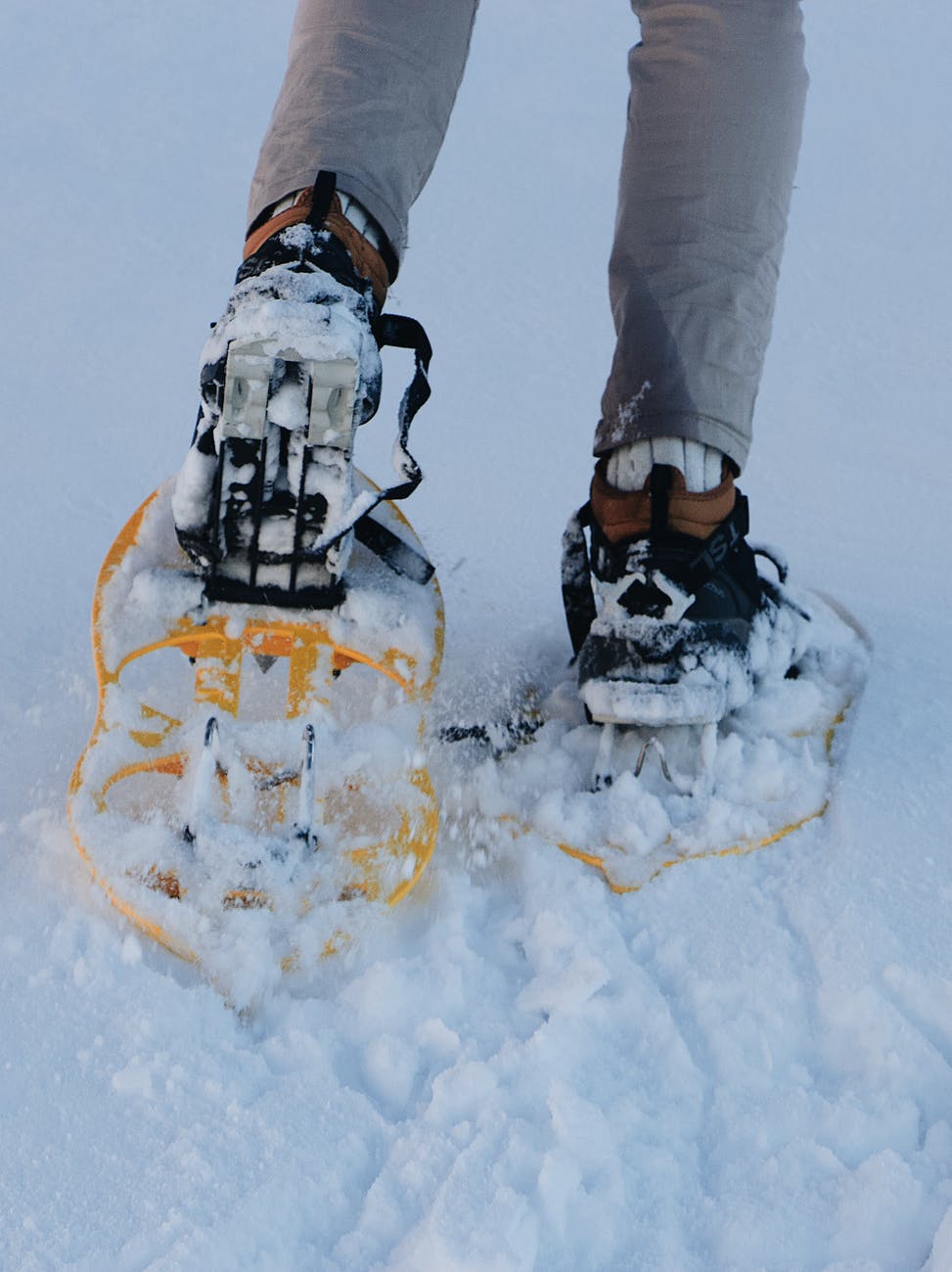 crop mountaineer walking on snowy track