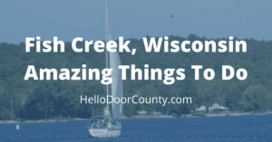 sail boat off the shore of Door County, Wisconsin, with a semi-transparent blue overlay, and the words: "Fish Creek, Wisconsin Amazing Things To Do hellodoorcounty.com"