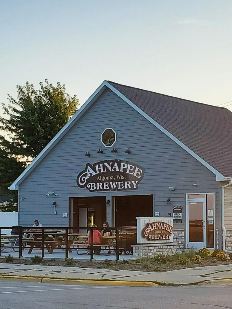 grey building sign that says Ahnapee Brewery Algoma, Wis.