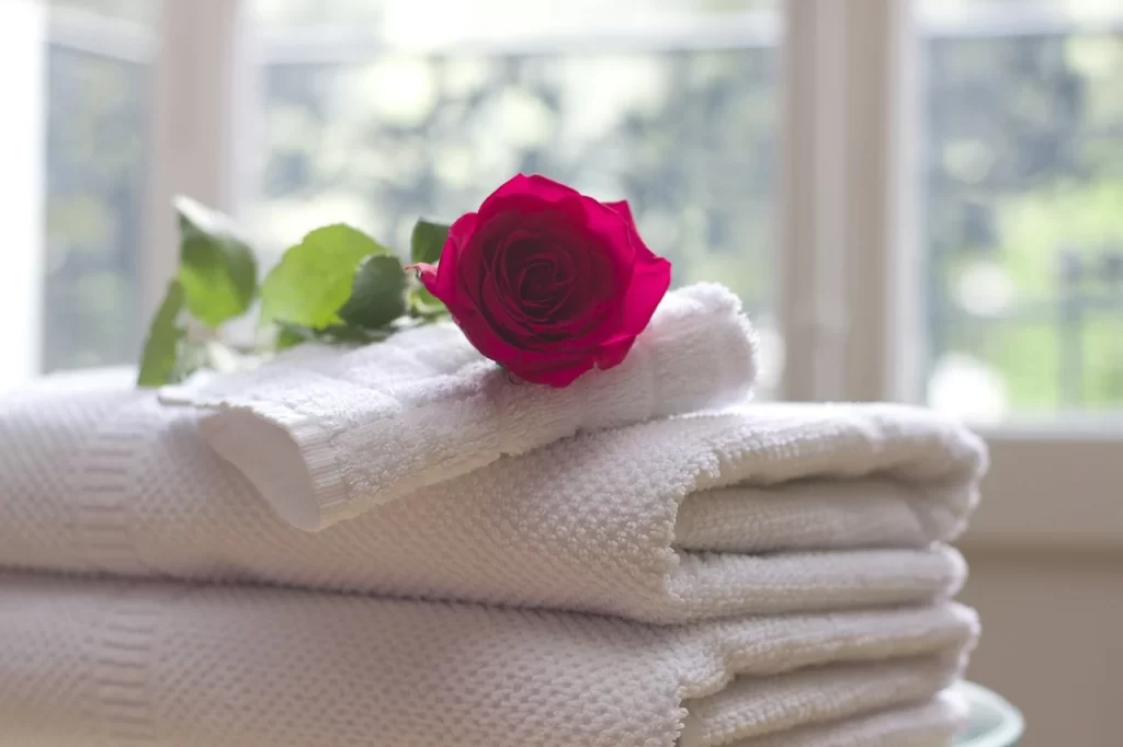 white bath towels with a red rose on top