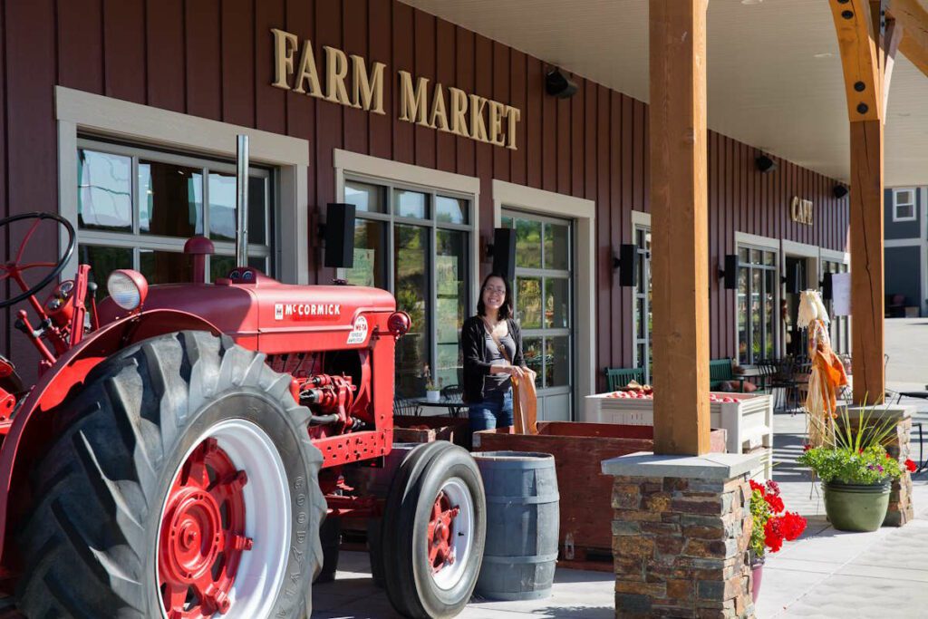 farm market scene with a red tractor and a customer and produce