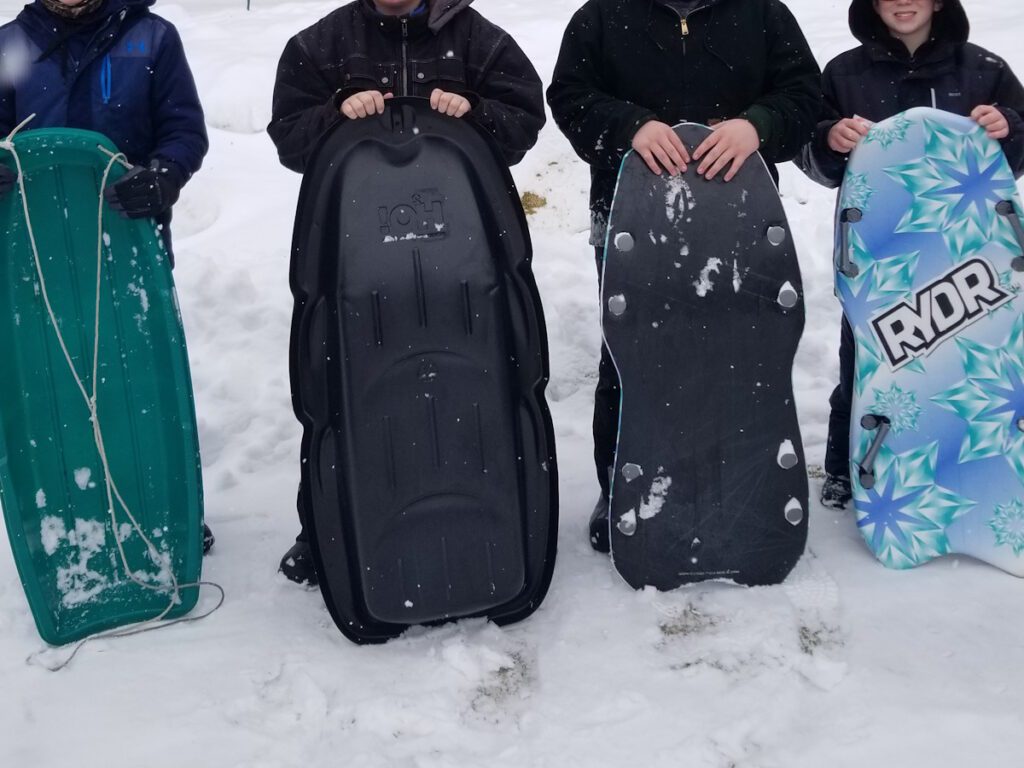 Four boys holding sleds in Door County, Wisconsin.