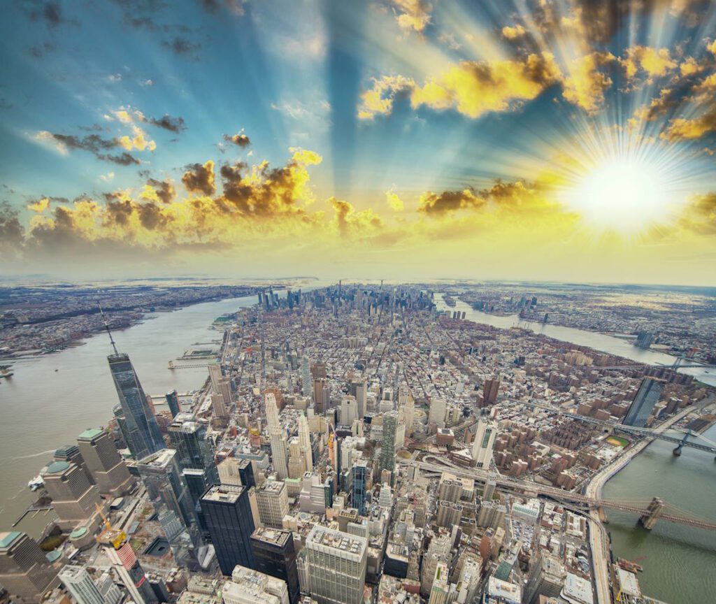 Panoramic aerial view of Downtown Manhattan at sunset, New York City from a high vantage point.