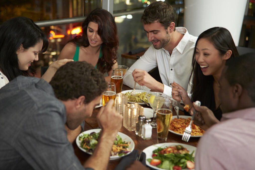 Group Of Friends Enjoying Evening Meal In Restaurant