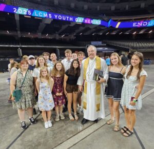 young people standing with a Lutheran pastor