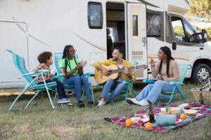 family sitting outside of an rv